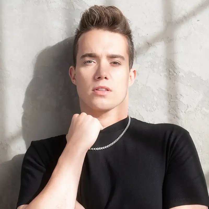 Parker Matthews Press Photo Parker Matthews leans against a wall with his fist under his chin